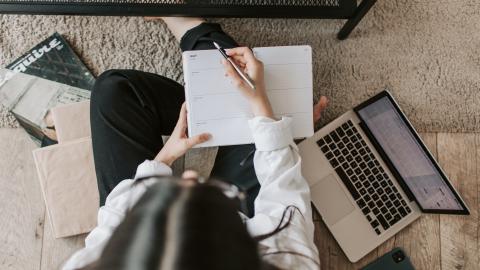 faceless lady with notebook and laptop at home